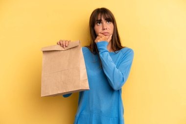 pretty woman thinking, feeling doubtful and confused. take away fast food concept