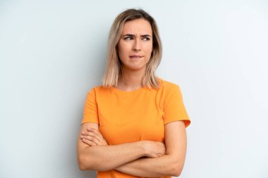 Genç ve güzel bir kadın şüpheye düşüyor ya da düşünüyor, dudağını ısırıyor ve kendini güvensiz ve gergin hissediyor, kenarda yer arıyor.
