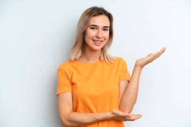 Genç ve güzel bir kadın gururla ve güvenle gülümsüyor, mutlu ve tatmin olmuş hissediyor ve fotokopi alanında bir konsept gösteriyor.