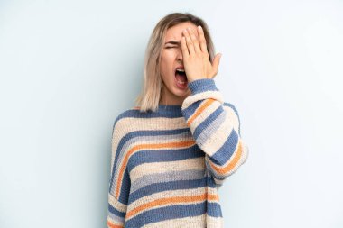 Genç ve güzel bir kadın uykulu görünüyor, sıkılmış ve esniyor, baş ağrısı ve yüzünün yarısını kaplayan bir eliyle