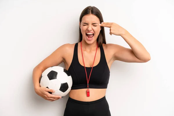 pretty girl looking unhappy and stressed, suicide gesture making gun sign. soccer and fitness concept