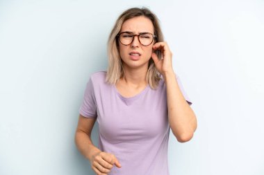 Genç ve güzel bir kadın stresli, hayal kırıklığına uğramış ve yorgun hissediyor. Endişeli ve sorunlu bir bakışla boynunu ovalıyor.