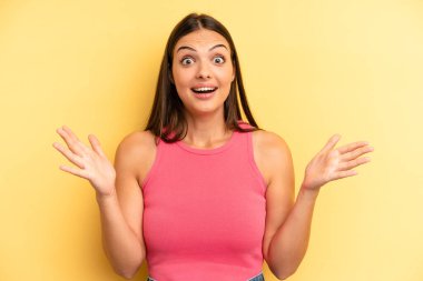 Genç, güzel bir kadın mutlu, heyecanlı, şaşırmış ya da şok olmuş, gülümseyen ve hayrete düşmüş.