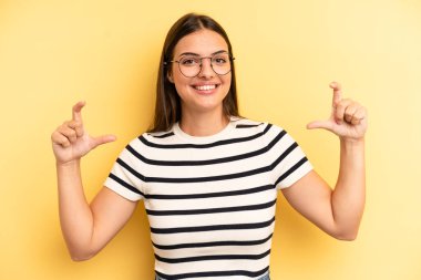 young adult pretty woman framing or outlining own smile with both hands, looking positive and happy, wellness concept