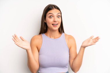 young adult pretty woman feeling happy, excited, surprised or shocked, smiling and astonished at something unbelievable