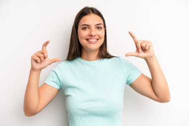 Genç, güzel bir kadın iki eliyle kendi gülüşünü çiziyor. Olumlu ve mutlu görünüyor. Sağlık kavramı.