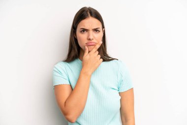 young adult pretty woman looking serious, confused, uncertain and thoughtful, doubting among options or choices