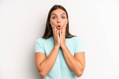 young adult pretty woman feeling shocked and scared, looking terrified with open mouth and hands on cheeks