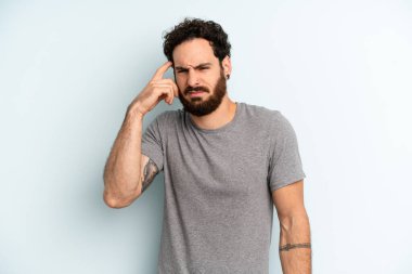 Genç, sakallı, kafası karışmış, kafası karışmış genç bir adam. Deli, deli ya da aklını kaçırmış olduğunu gösteriyor.