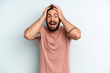 Genç, sakallı, el ele tutuşan, ağzı açık, son derece şanslı, şaşırmış, heyecanlı ve mutlu bir adam.