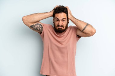 Genç, sakallı, bıkkın, bıkkın, başarısızlıktan bıkmış, sıkıcı işlerden bıkmış genç bir adam.