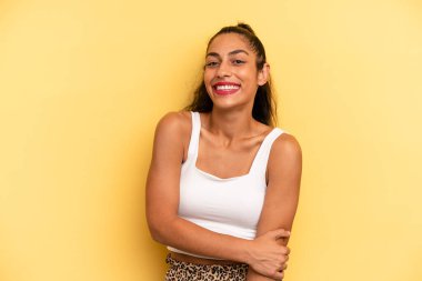 İspanyol güzel kadın utangaç ve neşeli bir şekilde gülüyor, arkadaş canlısı ve olumlu ama güvensiz bir tavırla.