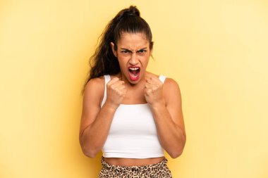İspanyol asıllı güzel bir kadın sinirli, sinirli bakışlar ve sıkı yumruklar ile agresif bir şekilde bağırıyor.