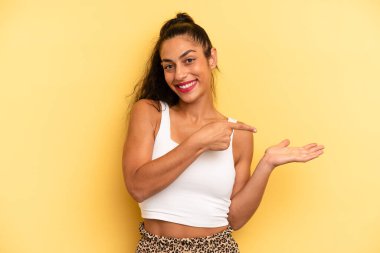 İspanyol güzel kadın gülümsüyor, mutlu, kaygısız ve tatmin olmuş hissediyor, fotokopi alanındaki konsepte ya da fikre işaret ediyor.