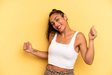 İspanyol güzel kadın gülümsüyor, kaygısız hissediyor, rahat ve mutlu, dans ediyor ve müzik dinliyor, bir partide eğleniyor.