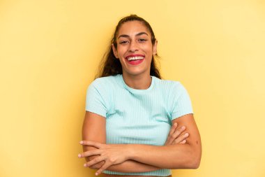 İspanyol güzel kadın mutlu, gururlu ve tatmin olmuş görünüyor. Kollarını kavuşturup gülümsüyor.