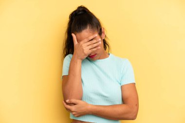 İspanyol güzel kadın stresli, utanmış ya da üzgün görünüyor, baş ağrısı var, yüzünü eliyle kapatıyor.