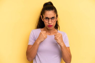 İspanyol güzel kadın kendinden emin, sinirli, güçlü ve agresif görünüyor. Yumrukları boks pozisyonunda dövüşmeye hazır.