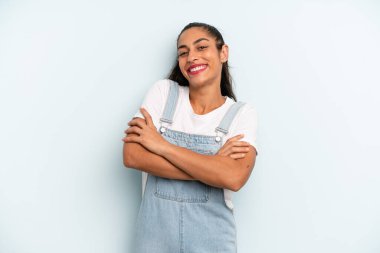 İspanyol güzel kadın kollarını kavuşturup mutlu bir şekilde gülüyor, rahat, pozitif ve tatmin edici bir pozla.