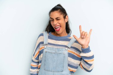 İspanyol güzel kadın kendini mutlu, eğlenceli, kendinden emin, pozitif ve asi hissediyor, elle rock veya heavy metal işareti yapıyor.