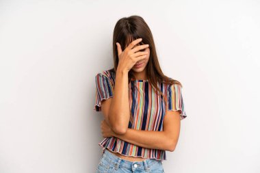 İspanyol güzel kadın stresli, utanmış ya da üzgün görünüyor, baş ağrısı var, yüzünü eliyle kapatıyor.