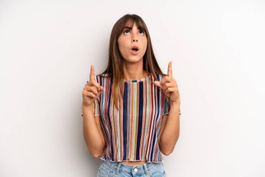 Hispanik güzel kadın şaşkınlık içinde ve ağzı açık. Şok olmuş ve şaşırmış bir bakışla yukarı bakıyor.