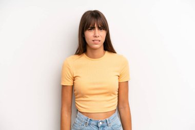 hispanic pretty woman feeling puzzled and confused, with a dumb, stunned expression looking at something unexpected