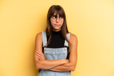 Hispanik güzel kadın şüpheye düşüyor ya da düşünüyor, dudağını ısırıyor ve kendini güvensiz ve gergin hissediyor, kenarda yer arıyor.