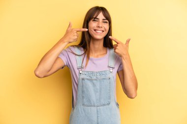 İspanyol güzel kadın kendine güvenerek gülümsüyor. Geniş gülümseme, pozitif, rahat, tatmin olmuş tavır.