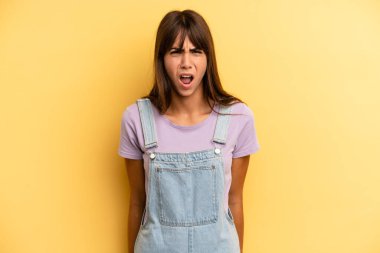 Şok olmuş, kızgın, sinirli ya da hayal kırıklığına uğramış, ağzı açık ve öfkeli görünen İspanyol güzel kadın.