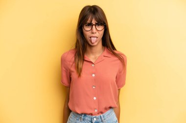 İspanyol güzel kadın tiksinmiş ve rahatsız olmuş hissediyor, dilini dışarı çıkarıyor, iğrenç ve iğrenç bir şeyden hoşlanmıyor.