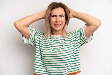 Genç sarışın kadın kendini stresli, endişeli ya da korkmuş hissediyordu. Elleri başının üstünde, hatayla panikliyordu.