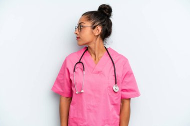 İspanyol kadın profil görüşünde düşünüyor, hayal ediyor ya da hayal kuruyor. hemşire konsepti