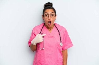 İspanyol kadın şok olmuş ve ağzı açık, kendini işaret ederek şaşırmış görünüyor. hemşire konsepti