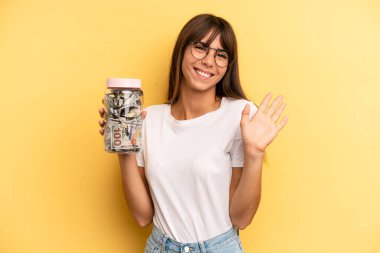 İspanyol kadın mutlu bir şekilde gülümsüyor, el sallıyor, sizi selamlıyor ve selamlıyor. kaydetme kavramı