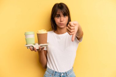 feeling cross,showing thumbs down. take away coffees
