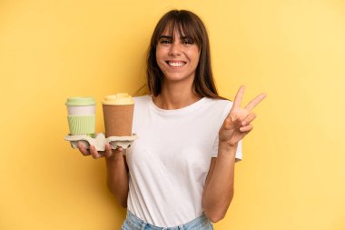 smiling and looking friendly, showing number two. take away coffees