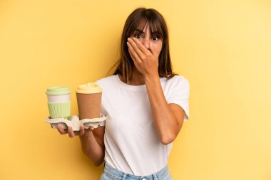 covering mouth with hands with a shocked. take away coffees