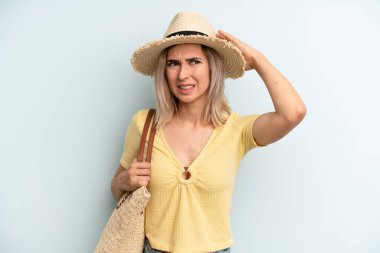 blonde woman feeling stressed, anxious or scared, with hands on head. summer concept