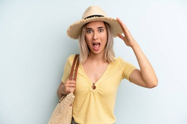 blonde woman looking happy, astonished and surprised. summer concept