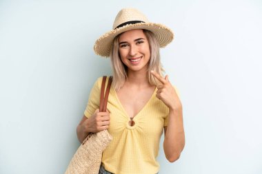 blonde woman smiling confidently pointing to own broad smile. summer concept