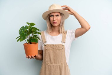 Sarışın kadın mutlu bir şekilde gülümsüyor ve hayal kuruyor ya da şüphe ediyor. gardering konsepti