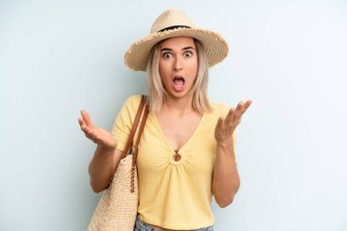blonde woman feeling extremely shocked and surprised. summer concept