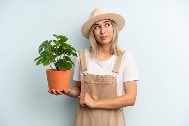 Sarışın kadın omuz silkiyor, kafası karışık ve kararsız. gardering konsepti