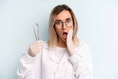 Sarışın kadın şok olmuş ve korkmuş hissediyor. dişçi kavramı