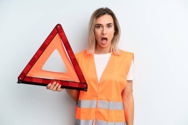 Sarışın, güzel bir kadın çok şaşırmış ya da şaşırmış görünüyor. araba acil konsepti