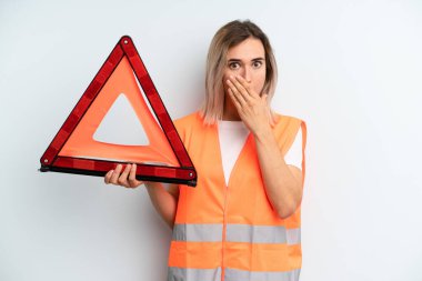 Sarışın, güzel bir kadın, elleri ve ağzı şok olmuş bir şekilde kapatıyor. araba acil konsepti