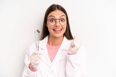 Güzel kadın şokta, gülüyor ve başarıyı kutluyor. dişçi kavramı