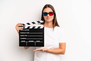 Güzel bir kadın neşeyle gülümser, mutlu hisseder ve bir konsept gösterir. film veya film konsepti