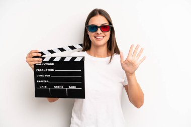 Güzel bayan gülümsüyor ve arkadaş canlısı görünüyor, beş numarayı gösteriyor. film veya film konsepti